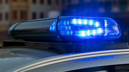 Ein Blaulicht auf einem Fahrzeug der Polizei leuchtet in der Dunkelheit. 