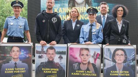 Die auf der neuen Imagekampagne der Berliner Polizei abgebildeten Polizisten halten ihre jeweiligen Plakate in den Händen.