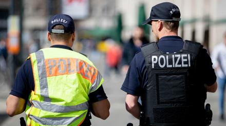 Zwei Polizeibeamte patrouillieren nebeneinander am Alexanderplatz.