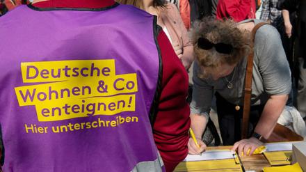 Beim bundesweiten Protesttag gegen steigende Mieten vom Bündnis gegen Verdrängung und #Mietenwahnsinn auf dem Alexanderplatz unterschreibt eine Frau eine Liste für die Enteignungsinitiative.
