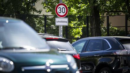 Ein Verkehrsschild zur Vorgabe der maximalen Geschwindigkeit auf 30 km/h hängt über dem Schild Luftreinhaltung auf der Leipziger Straße in Berlin.
