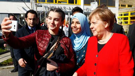 Schülerinnen des Thomas-Mann-Gymnasiums machen Selfies mit Angela Merkel.