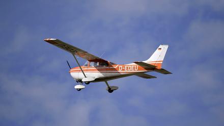 Einmotoriges Kleinflugzeug fliegt an wolkigem Himmel.