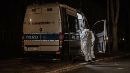 Kriminaltechniker stehen am frühen Sonntagmorgen an ihrem Einsatzfahrzeug an einem Wohnhaus im Berliner Bezirk Reinickendorf. 