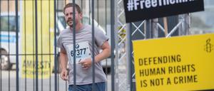Kraftakt im Käfig. Peter Steudtner rennt am Potsdamer Platz. Mit seiner Aktion will er auf die repressive Politik gegenüber Menschenrechtsaktivisten weltweit aufmerksam machen. 