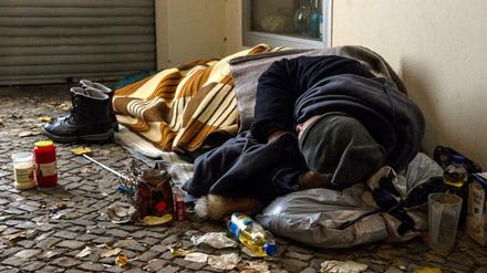 Ein Obdachloser liegt in Berlin in einem Hauseingang. 