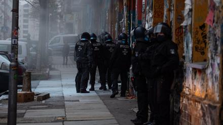 Polizisten stehen vor einem Haus in der Rigaer Straße.