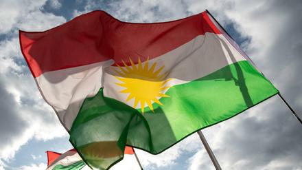 Demonstranten halten am Pariser Platz Fahnen der Autonomen Region Kurdistan.
