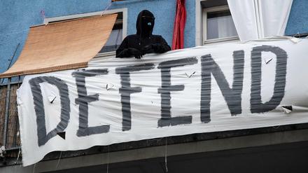 Ein vermummter Mann steht auf einem Balkon eines Hauses in der Rigaer Straße. Die Autonomen werden ihr Hausprojekt auch mit Gewalt verteidigen, kündigten sie an.