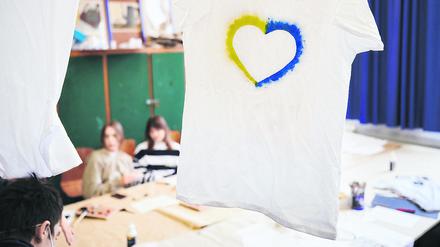 Ein T-Shirt mit einem Herz, umrahmt von den ukrainischen Farben hängt im Klassenraum einer Willkommensklasse am Willy-Graf-Gymnasium in Berlin-Lichterfelde. 
