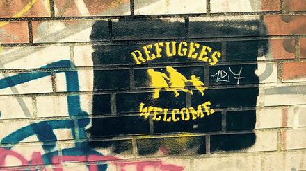 Ein Refugees Welcome Grafitti wurde an eine Backsteinmauer gesprayt.