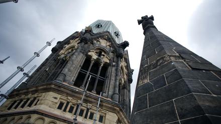  Turm der Kaiser-Wilhelm-Gedächtniskirche in Berlin ragt auf in dunkle Wolken.