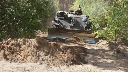 Ein Panzer der Bundeswehr schneidet bei Klausdorf eine Schneise in den Wald, damit die Feuerwehrleute besser an die Glutherde herankommen. 
