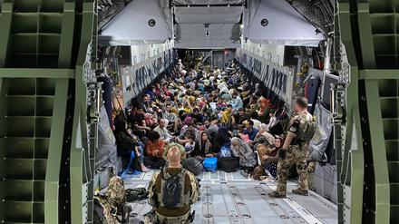 Geflüchtete sitzen in einem Airbus A400M der Bundeswehr. Die Bundeswehr hat weitere deutsche Staatsbürger und afghanische Ortskräfte aus Kabul evakuiert. +++ dpa-Bildfunk +++