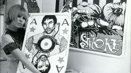 März 1968. Eine Frau präsentiert in ihrem Postershop in Berlin ein Plakat von Rudi Dutschke.