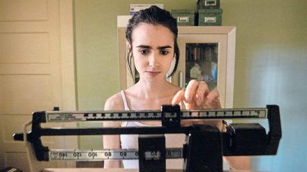 Ellen (Lily Collins) muss feststellen, dass sie weiter an Gewicht verlieren. Szene aus dem Netflix-Film "To the Bone".