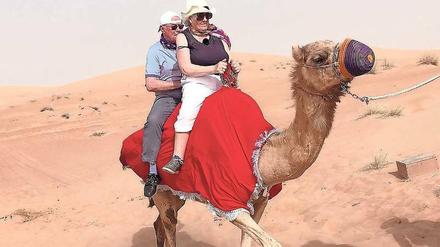 Das erste Mal Kamelreiten. Die Rentner Bernd und Christina in der Wüste nahe Dubai. Alles unter dem Blick von Reiseführer Steven Gätjen.