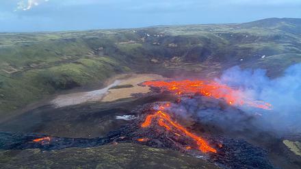 Eine Luftaufnahme der Küstenwache zeigt, wie Lava aus dem Vulkan Fagradalsfjall fließt und Rauch aufsteigt.