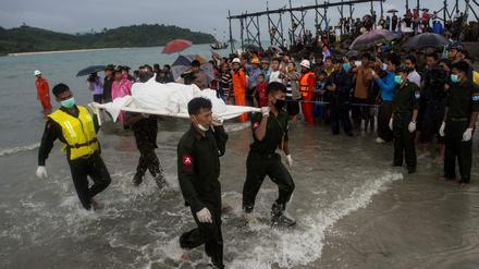 Militärangehörige von Myanmar bergen nahe des Ortes Sanhlan auf einer Trage eines der Opfer des Flugzeugunglücks. 