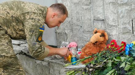 Ein ukrainischer Soldat zündet eine Kerze am Ort des russischen Beschusses in Winnyzia ab.