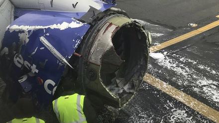 Die zerstörte Turbine eines Flugzeugs der Fluggesellschaft Southwest Airlines wird untersucht. In den USA ist eine Frau in einem Flugzeug nach Medienberichten erst von Teilen einer zerstörten Turbine getroffen und dann fast aus dem Fenster gerissen worden. Andere Fluggäste hätten sie festgehalten, berichteten mitreisende Passagiere im Sender CNN und auf Facebook. +++ dpa-Bildfunk +++