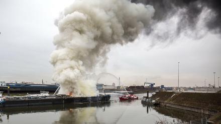 Ein Feuerlöschboot löscht am Donnerstag in Duisburg ein Schiff. Zwei Menschen sind bei Arbeiten auf dem Tankschiff in einer Werft im Duisburger Hafen ums Leben gekommen.
