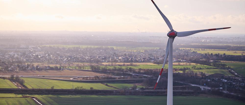 Von einem Berliner Windrad in Pankow sieht man Berlin unter den Wolken und ein weiteres Windrad nebenan.