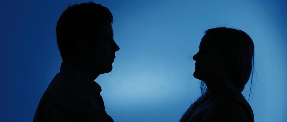 Ein als Silhouette abgebildeter Mann und eine Frau stehen sich am 08.01.2013 in Berlin mit verschränkten Armen gegenüber.