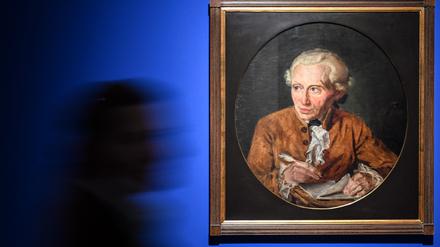 Eine Besucherin geht in einer Ausstellung an dem Bild „Immanuel Kant am Schreibtisch“ aus dem Jahr 1872 von Johannes Haydeck vorbei.