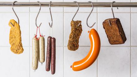 Vegan and vegetarian sausages and steaks hanging on hooks