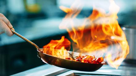 Modern kitchen. Cooks prepare meals on the stove in the kitchen of the restaurant or hotel. The fire in the kitchen