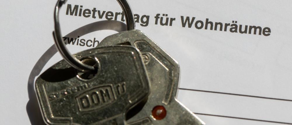 Ein Wohnungsschlüssel liegt auf einem Mietvertrag für eine Wohnung.