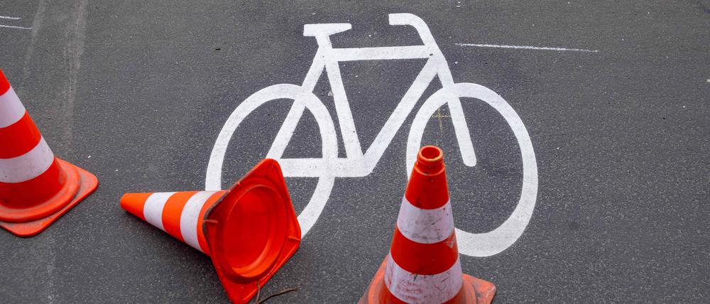 Leitkegel sichern ein frisch gemaltes Fahrradsymbol auf dem Radweg entlang der Schönhauser Allee in Berlin-Prenzlauer Berg.