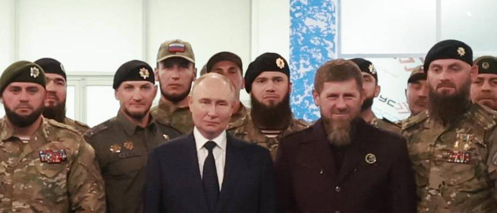 Der russische Präsident Wladimir Putin, das Oberhaupt der Tschetschenischen Republik, Ramsan Kadyrow, und russische Soldaten stellen sich bei einem Besuch der Universität der russischen Spezialeinheiten für ein Gruppenfoto auf.