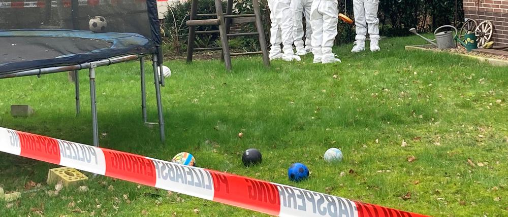 Beamte der Spurensicherung stehen vor einem Einfamilienhaus in der Gemeinde Scheeßel.
