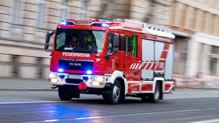 Ein Feuerwehrauto mit eingeschaltetem Blaulicht fährt zum Einsatz.