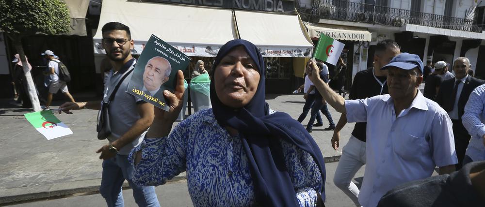 Anhänger des algerischen Präsidenten verteilen Handzettel für die Wiederwahl Tebbounes.
