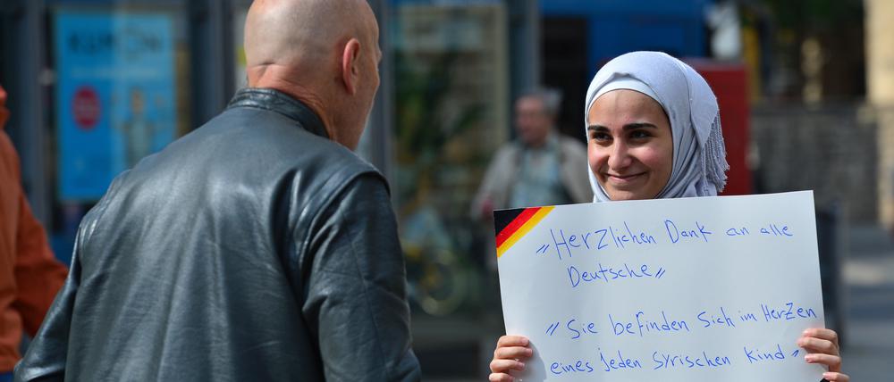 Ein Archivbild aus dem Jahr 2015: Eine junge Frau aus Syrien hält auf dem Anger in Erfurt (Thüringen) ein Schild mit der Aufschrift „Herzlichen Dank an alle Deutsche. Sie befinden sich im Herzen eines jeden syrischen Kind“ in den Händen.