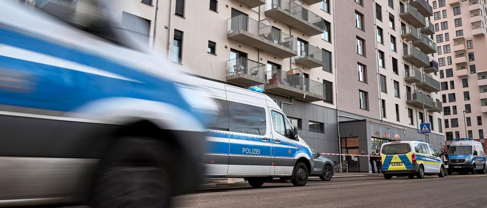 Polizeifahrzeuge stehen vor dem Wohngebäude. Im Fahrstuhl des Wohnhauses in Berlin-Marzahn ist nach Polizeiangaben eine schwer verletzte Frau gefunden worden, die kurz darauf gestoben ist.