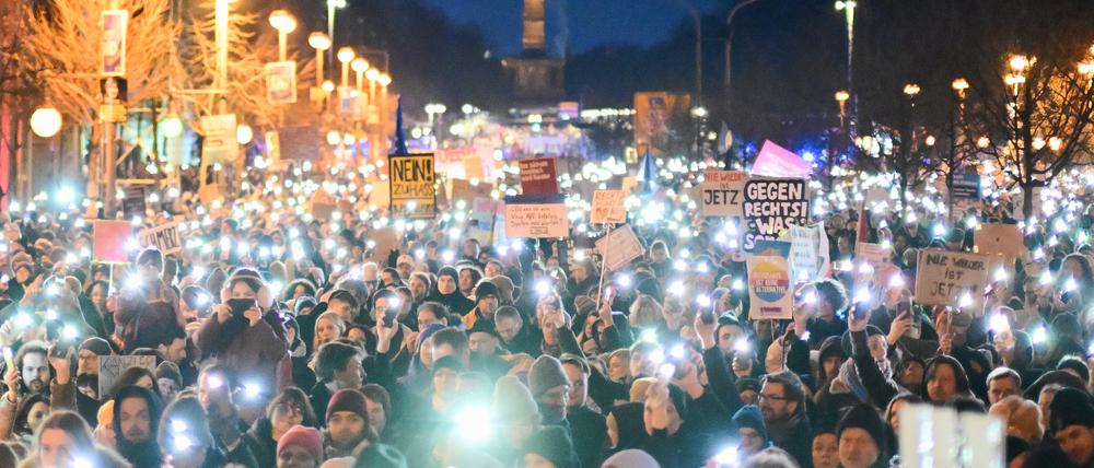 Teilnehmer der Demonstration am Sonntag halten Lichter hoch - im Hintergrund ist die Siegessäule zu sehen.