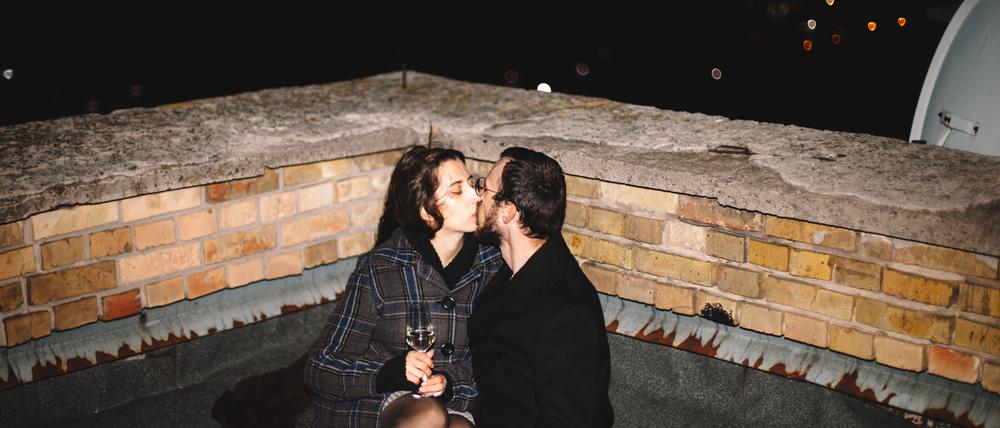 Frisch gefunden: Junges Paar knutscht auf einem Dach.