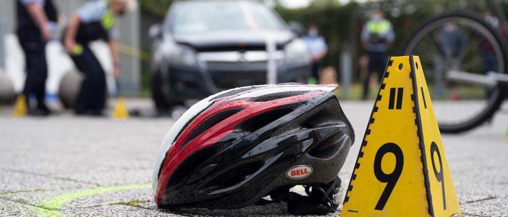 Ein Fahrradhelm liegt bei einer Verkehrsunfallaufnahme auf dem Boden. (Symbolbild)