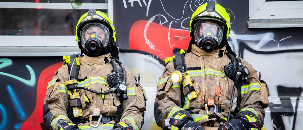Feuerwehrleute ruhen sich nach einem Einsatz in der Czeminskistraße in Berlin-Schöneberg aus.