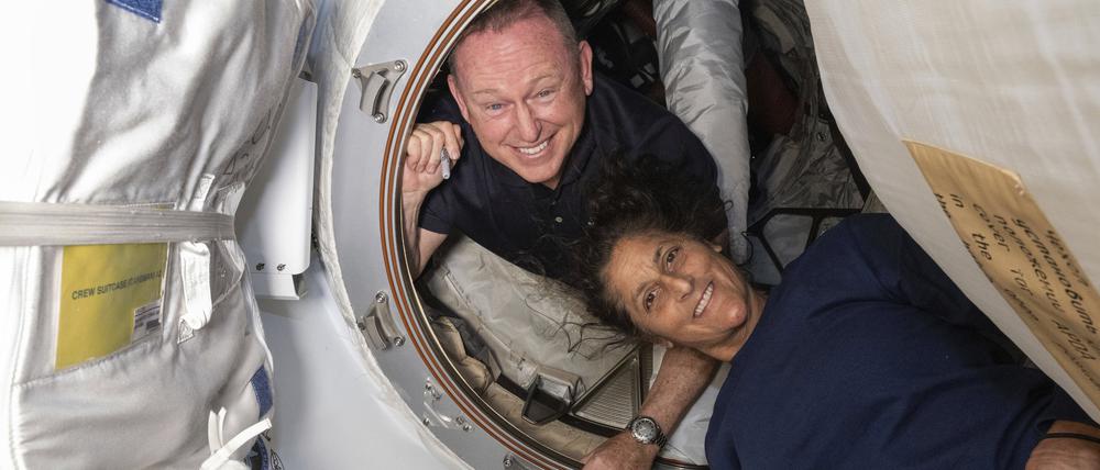 Die Astronauten Barry „Butch“ Wilmore (l.) und Suni Williams posieren vor der ISS.
