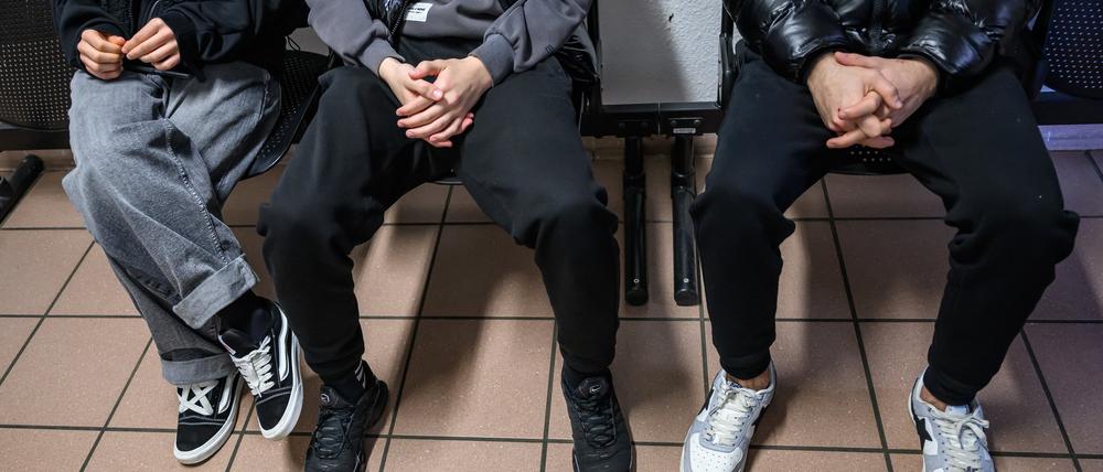 Drei junge Geflüchtete sitzen in einem Raum der Erstaufnahme auf dem Gelände der Zentralen Ausländerbehörde Brandenburgs (ZABH).