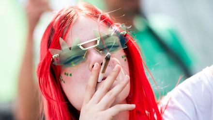 Eine Teilnehmerin raucht bei der 28. Hanfparade unter dem Motto „Legalisierung, aber richtig!“ einen Joint.