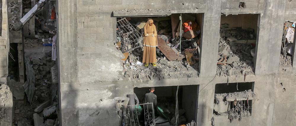 Palästinenser stehen in einem Gebäude, das durch einen israelischen Luftangriff beschädigt wurde.