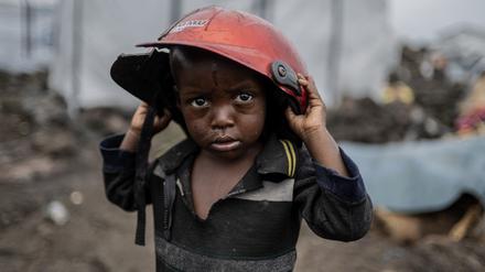 Ein Kind, das durch die Kämpfe zwischen M23-Rebellen und Regierungssoldaten vertrieben wurde, hält einen beschädigten Helm in einem Lager in Goma.