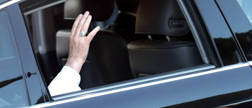 Der Papst winkt einer Menschenmenge aus seinem Wagen.