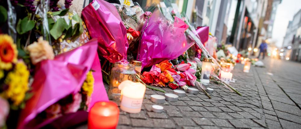 Blumen und Kerzen stehen in der Innenstadt an einer Hauswand in der Achternstraße, in der am Ostersonntag ein Mensch von Schüssen aus einer Polizeiwaffe tödlich verletzt wurde.